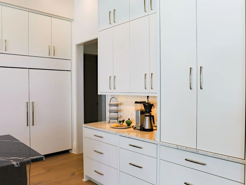 Built-in white storage cabinets with drawers and tall cabinet doors