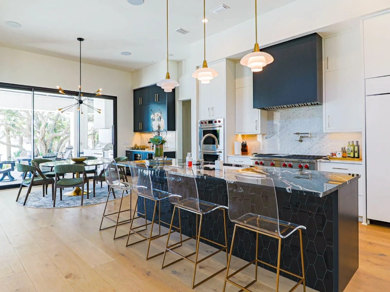 Open kitchen with island, dark accent cabinets, pendant lighting, and bar seating