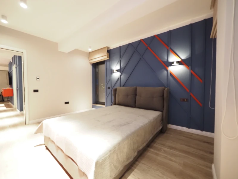 Apartment bedroom with window, curtains, bed, and warm wall finish