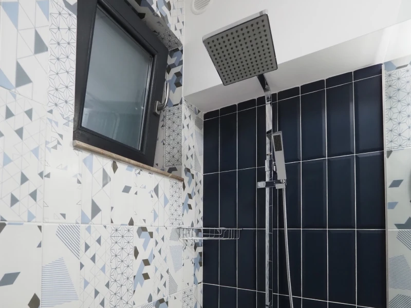 Apartment shower area with feature tile wall and black shower fittings