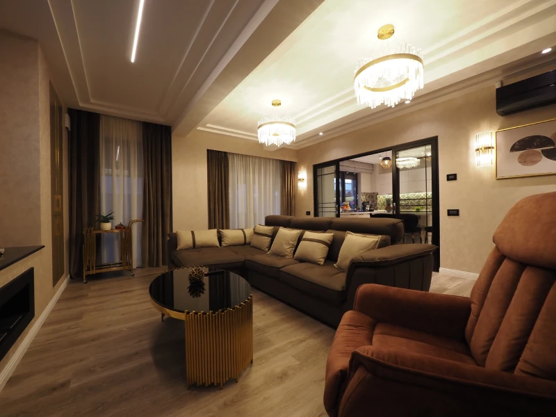Warm apartment living room interior with sofa seating and wood flooring